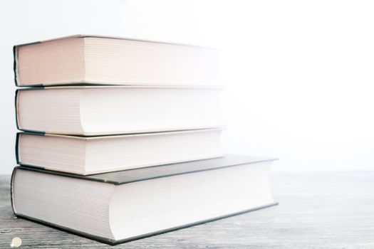 Thick paper books are a symbol of education and wisdom. A stack of books on the table. Storage and dissemination of information.