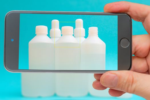 Antiseptic vials on smartphone screen. Disinfectant liquid in a white bottle. Therapeutic drug. Disinfection against coronavirus.