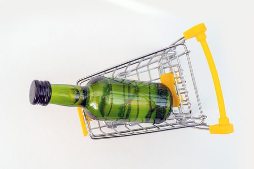 Selling alcohol in a store. Green bottle in a supermarket cart. Drink in a green bottle.