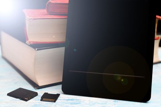 Modern e-book. Small memory cards. Old paper books.