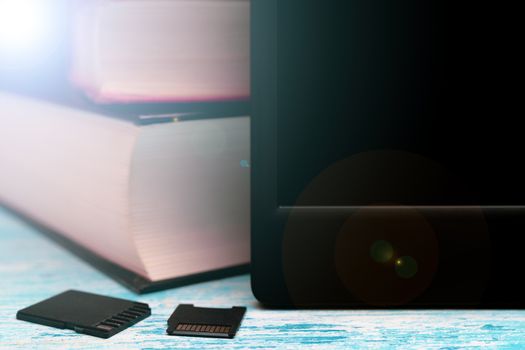 Modern e-book. Small memory cards. Old paper books.