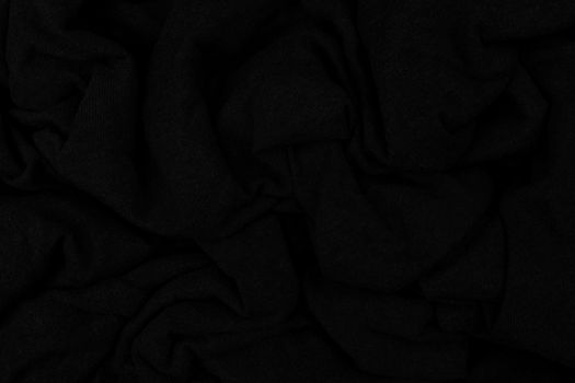 Folds of crumpled wool. Textile product. Abstract dark background.