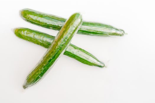 Ripe green long cucumbers. Vegetables on white background.