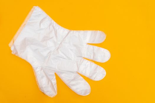 Transparent white protective gloves on yellow background. Protective clothing.