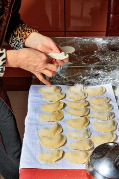 The housewife cooked raw dumplings and laid them on a cloth for subsequent cooking. Ukrainian national cuisine, close-up.