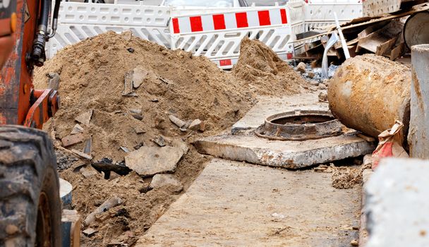 The old concrete blocks and the sewer hatch were dug up by the city services and put on the sidewalk to replace with new ones when repairing the city sewer. Copy space.