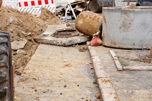 The old sewer manhole and concrete well require replacement with new ones when repairing the city collector on the roadway. Copy space.