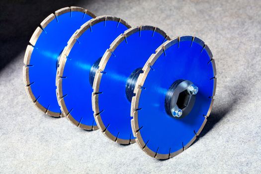 Diamond cutting discs for concrete and reinforced concrete are blue in color and are assembled in groups of three on a common shaft for breaking and making the strobes in the concrete surface.