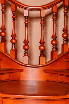 Fragment beautiful of a wooden staircase with figured carved balusters and railings and tinted mahogany.