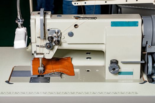 Modern machine for sewing furniture upholstery made of leather and various dense fabrics, the working part of the sewing machine close-up, copy space.