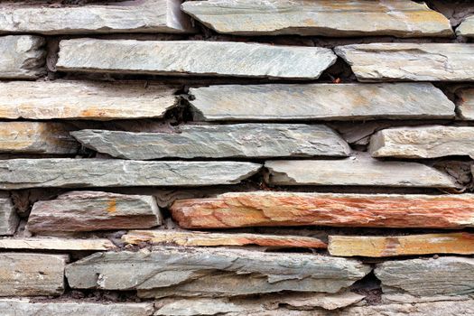 Detail part of the old stone retaining wall from of pieces of flat sandstone.