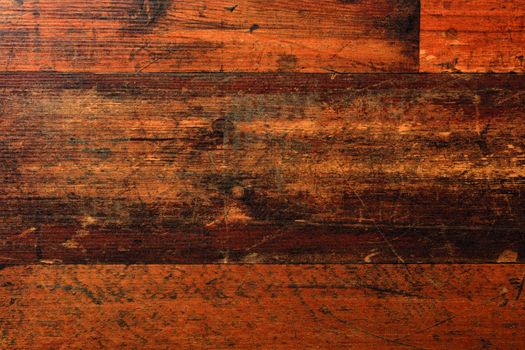 The beautiful texture of natural floorboards, worn and scratched over many years of use, with cracks, stains and a horizontal pattern of fibers.