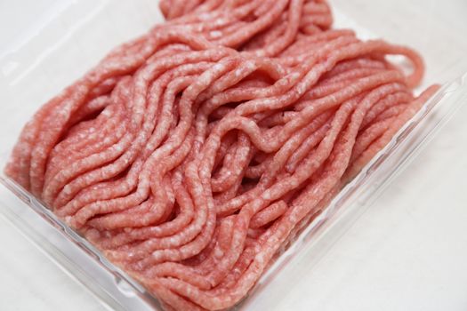 Ground pork in packing on the white table