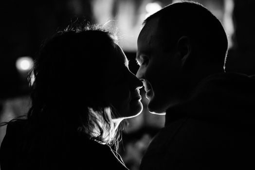 guy and girl are sitting in a wooden house on the background of a burning fireplace