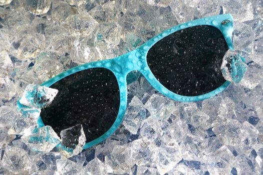 Water drops on blue sunglasses on a bed of ice