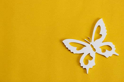 Minimal flatley composition, top view. White butterflies on a yellow background, a creative minimal concept, copy space.