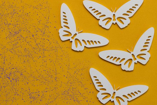 Minimal flatley composition, top view. White butterflies on a yellow background, a creative minimal concept, copy space.