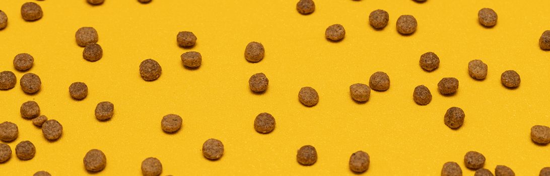 Balls of cat food on a yellow background. Background of pet food.