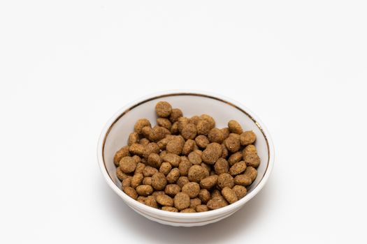 Balls of cat food in a beautiful bowl on a white background, isolate. The concept of pet food.