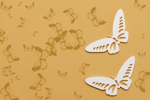 Minimal flatley composition, top view. White butterflies on a yellow background, a creative minimal concept, copy space.