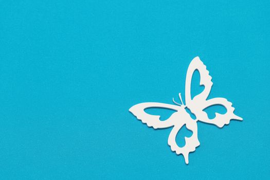 Minimal flatley composition, top view. White butterflies on a blue background, a creative minimal concept, copy space.