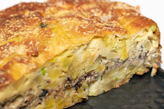 Homemade yeast-free cake on kefir with a filling of canned fish and potatoes, close-up. A hearty dish for a Flexitarian