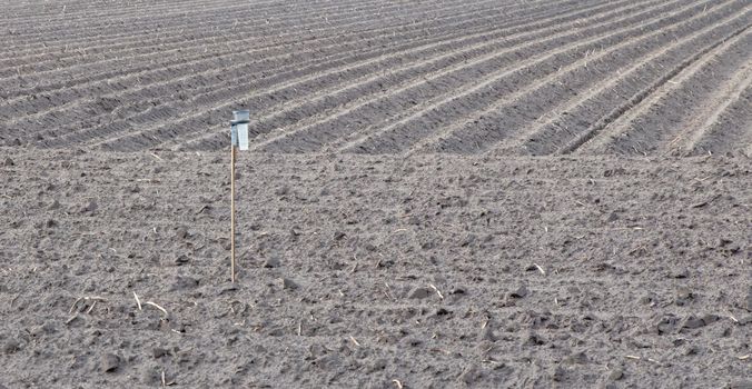 View of agricultural land prepared for sowing, arable soil, rain gauge, the Netherlands
