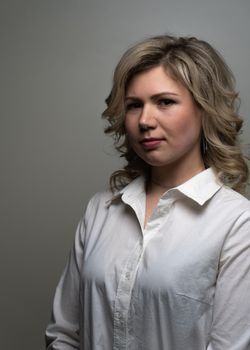 30 years old woman with blond hair in a white shirt posing in the studio