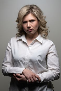 30 years old woman with blond hair in a white shirt posing in the studio