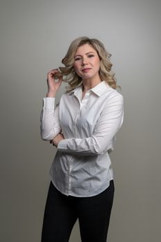 30 years old woman with blond hair in a white shirt posing in the studio