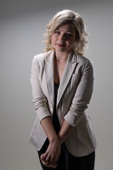 30 years old woman with blond hair in business clothes posing on a white background