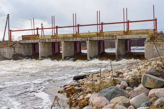 hydraulic structure, a dam through which a river flows, made of concrete and metal