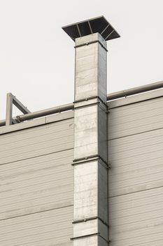 silver metal hood on a building wall, vertical frame