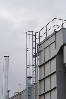 upper part of an industrial building with stairs, railings and other safety features