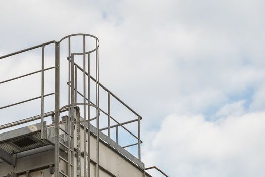 upper part of an industrial building with stairs, railings and other safety features