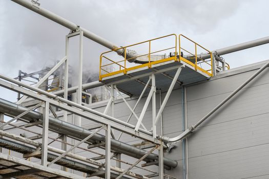 upper part of an industrial building with stairs, railings and other safety features