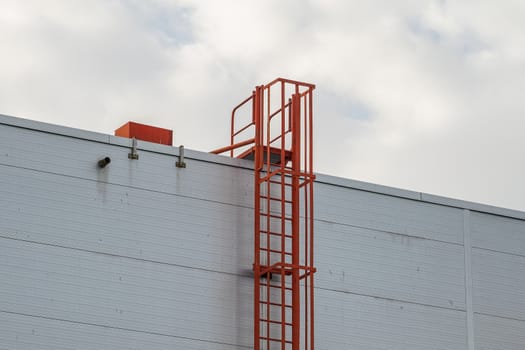 red fire escape leading to the roof of an industrial building