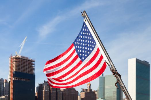 An American flag flies from a boat on the East River in New York City in the United States of America.