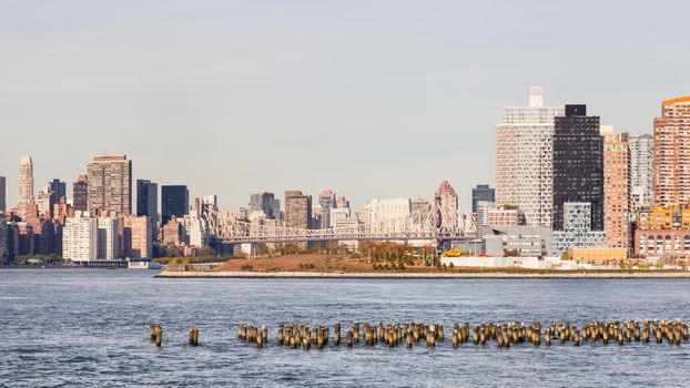 The view across the East River towards Hunter's Point South in Long Island City, New York City in the United States of America.  Roosevelt Island and Queensboro Bridge passing over the island can also be seen.