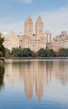 The view across the Jackie Onassis Reservoir in Central Park, New York City in the United States of America on a still autumn morning.