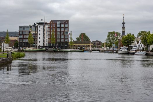 harbor boats and first buildings that are seen when entering the city of alkmaar netherlands holland