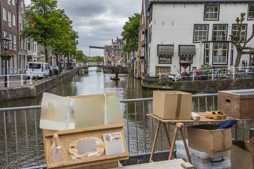 view of an alkmaar canal in the foreground a market business and in the background the canal with a boat carrying cheese and a drawbridge. netherlands holland