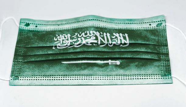 surgical mask with the national flag of Saudi Arabia printed. Pandemic covid-19 and preventive measures to counter the spread of the virus