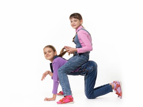 Two girls play horse on a white background