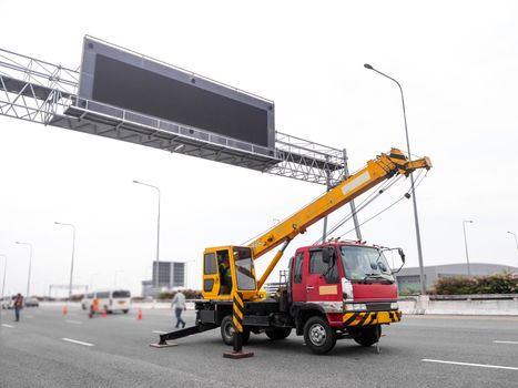 Construction site crane is lifting a led signboard Blank billboard on blue sky background for new advertisement