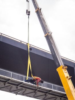 Construction site crane is lifting a led signboard Blank billboard on blue sky background for new advertisement