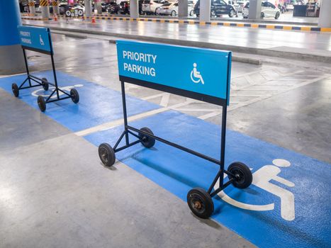 The international sign for a handicapped parking stall in a parking lot. Priority parking sign.