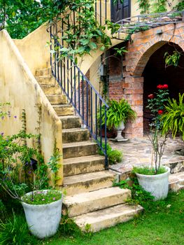 House frontyard cultured veneer stone work siding and rod iron stairs