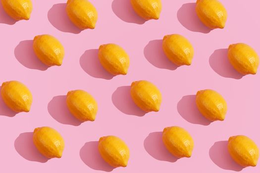 Trendy yellow lemon isometric pattern on pink background. Creative and modern minimal concept. Summer fresh flat lay food texture, copy space.
