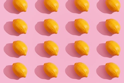 Trendy yellow lemon isometric pattern on pink background. Creative and modern minimal concept. Summer fresh flat lay food texture, copy space.
